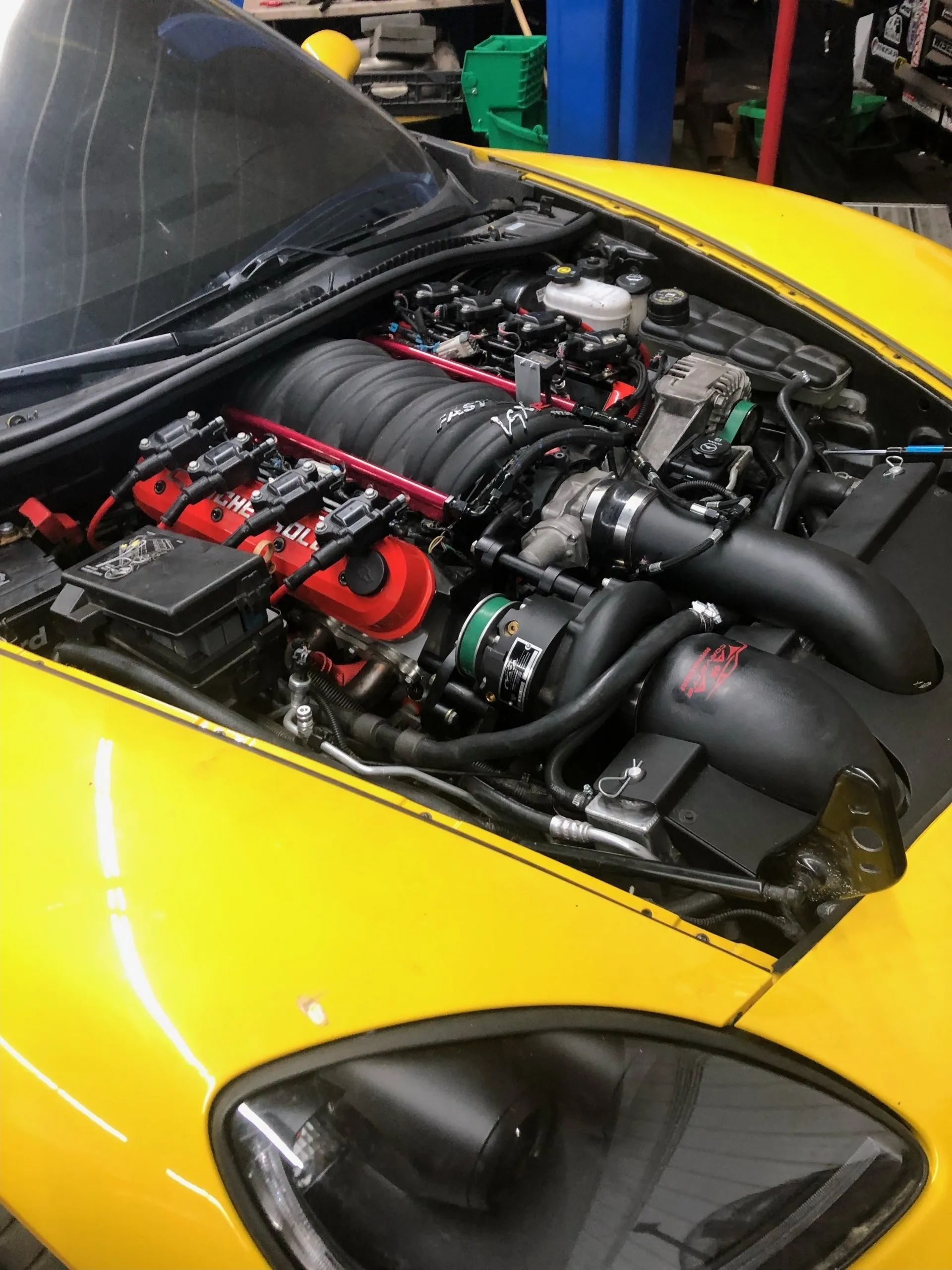 Yellow Corvette engine bay with red details, black air intake.