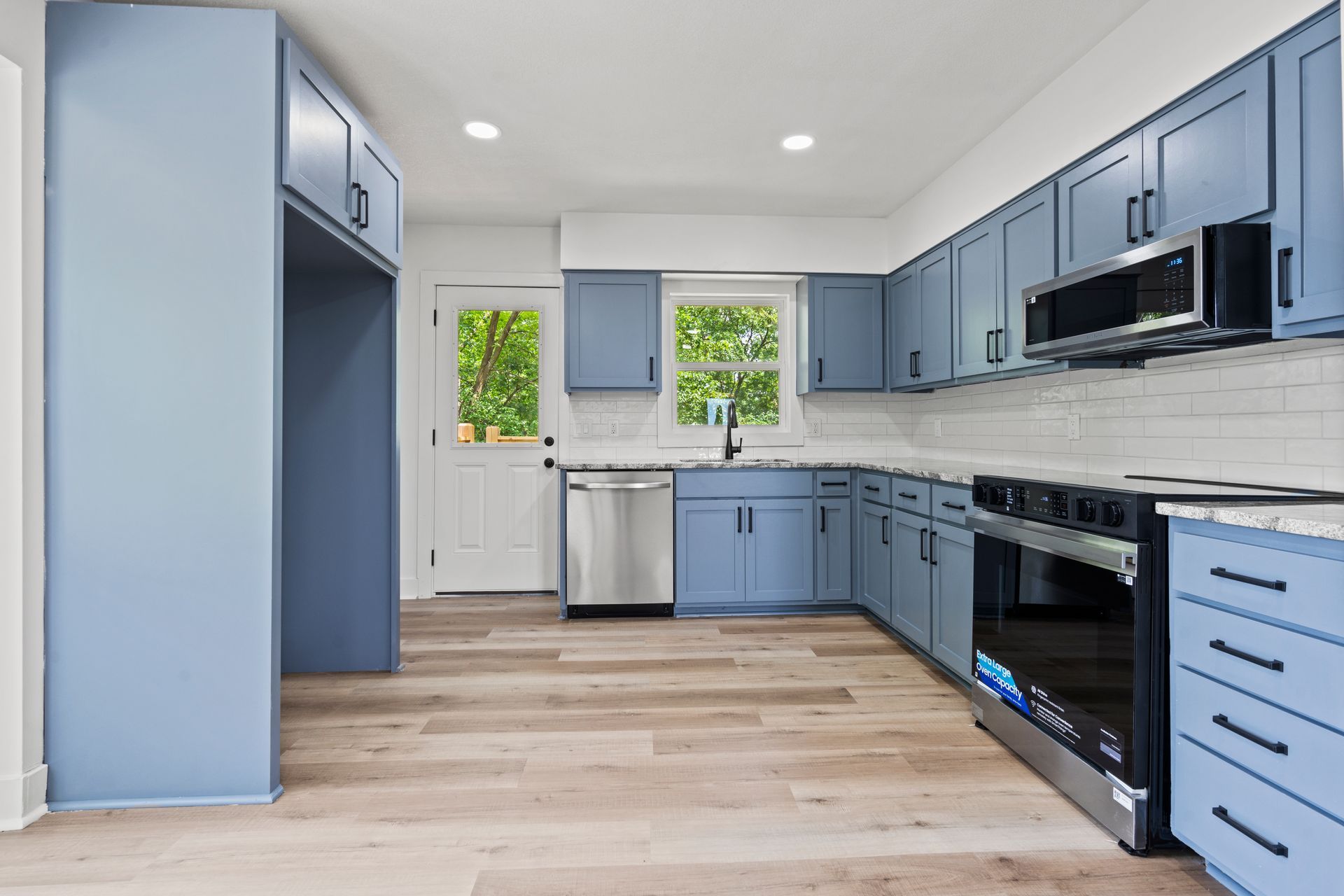 A kitchen with blue cabinets and stainless steel appliances