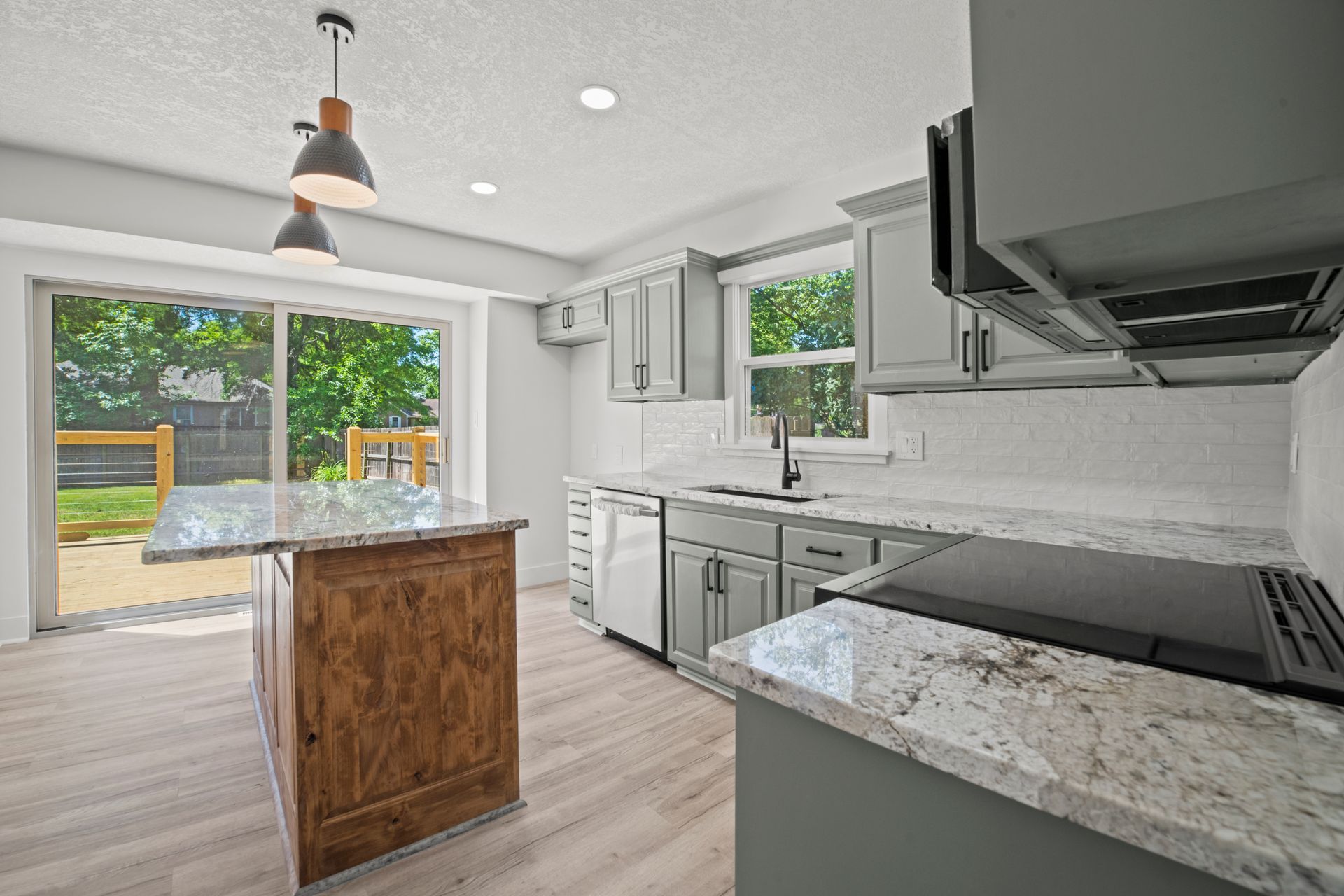 A kitchen with granite counter tops , stainless steel appliances , and a large island.