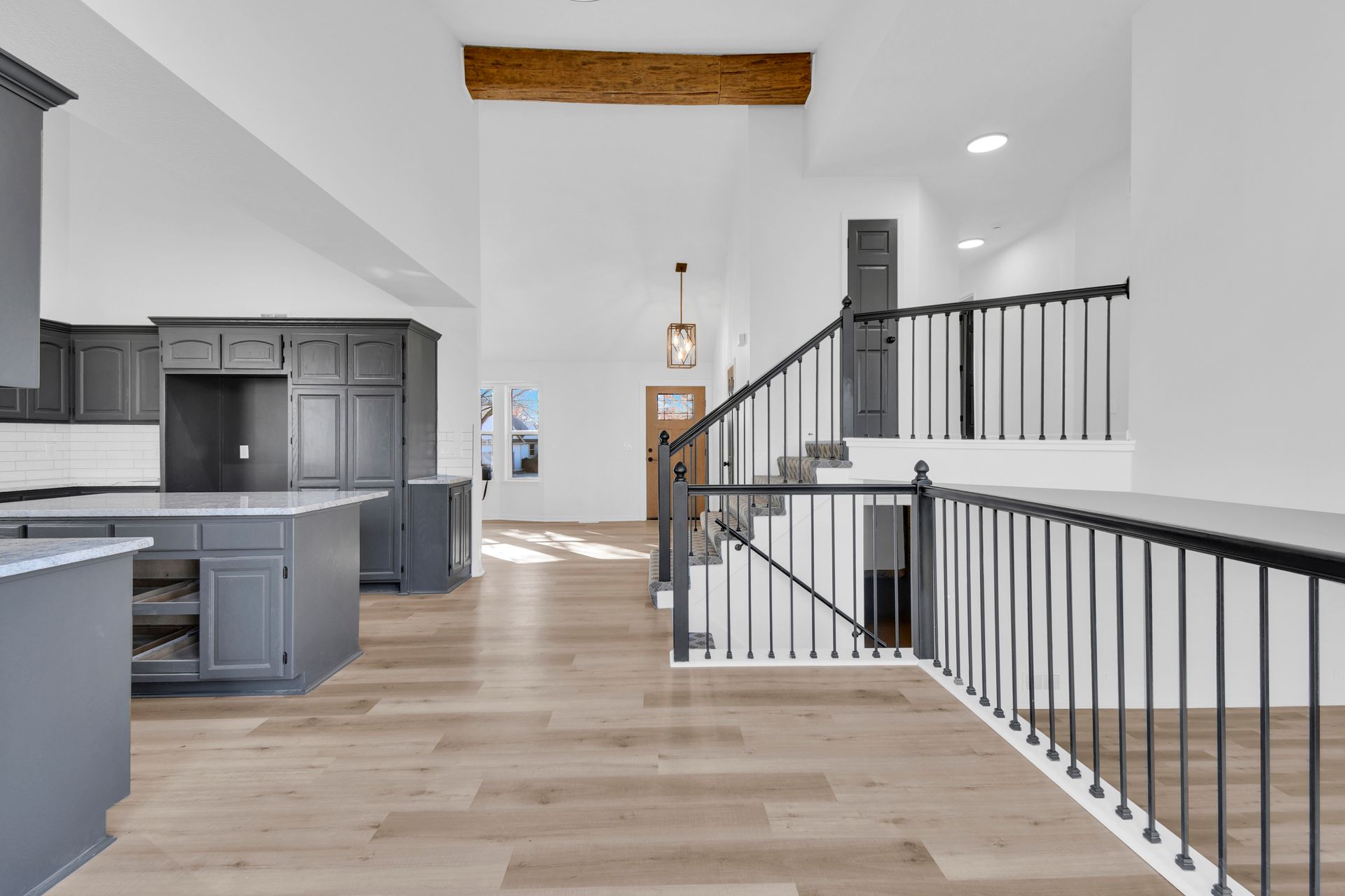 A kitchen with a staircase leading up to the second floor.
