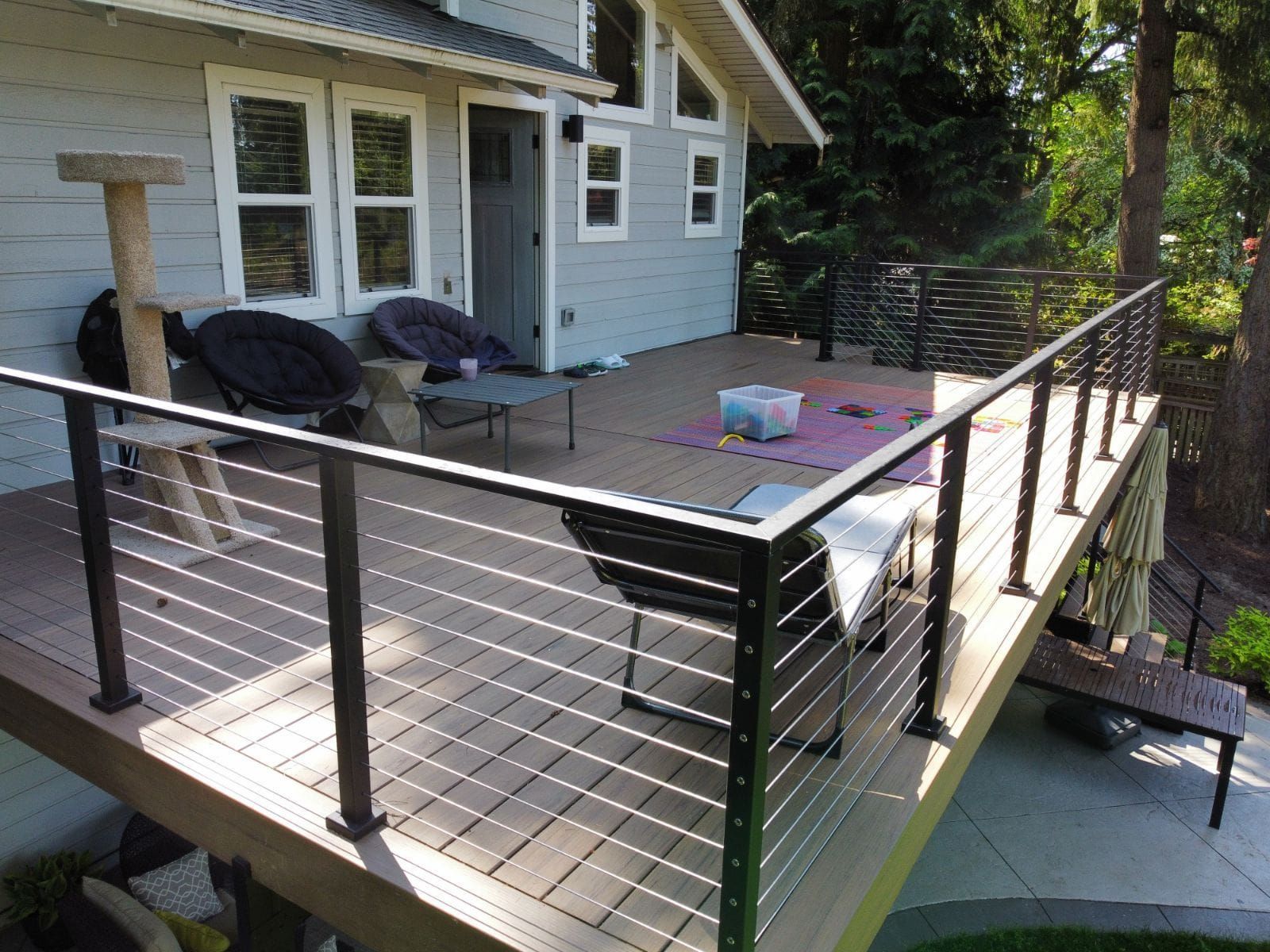 A deck with chairs and a cat tree on it