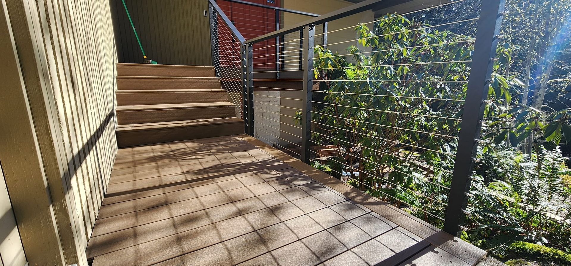 A balcony with a railing and stairs next to a building.