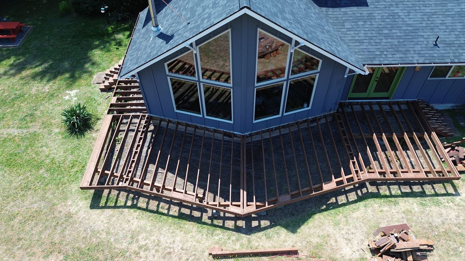 An aerial view of a house with a large deck in front of it.