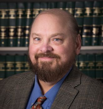 A man with a beard is wearing a suit and tie.