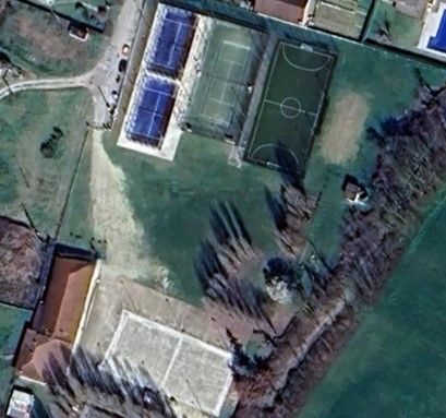 Vista aerea del complesso sportivo con campi da tennis, campo da calcio e spazi verdi aperti.