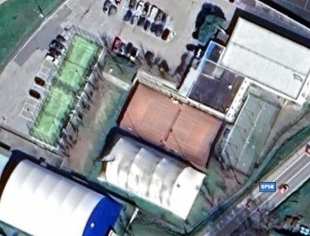 Vista aerea del complesso sportivo con campi all'aperto, campi coperti e parcheggio.