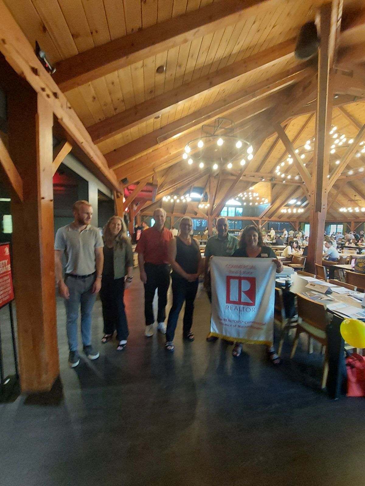 A woman is sitting at a table with a house and two cars.