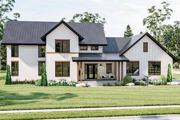 Modern two-story farmhouse with white siding, black roof, and green lawn under a bright sky