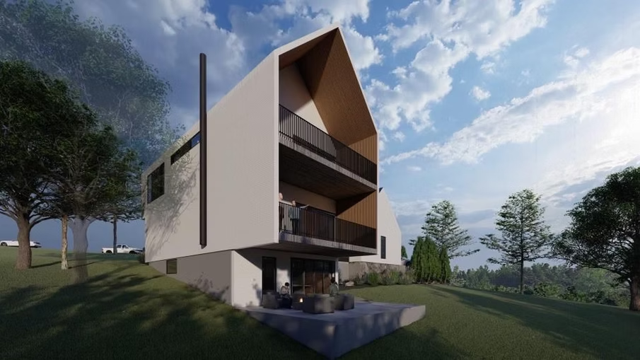 Modern angular house with wood accents on a grassy hillside under a cloudy sky