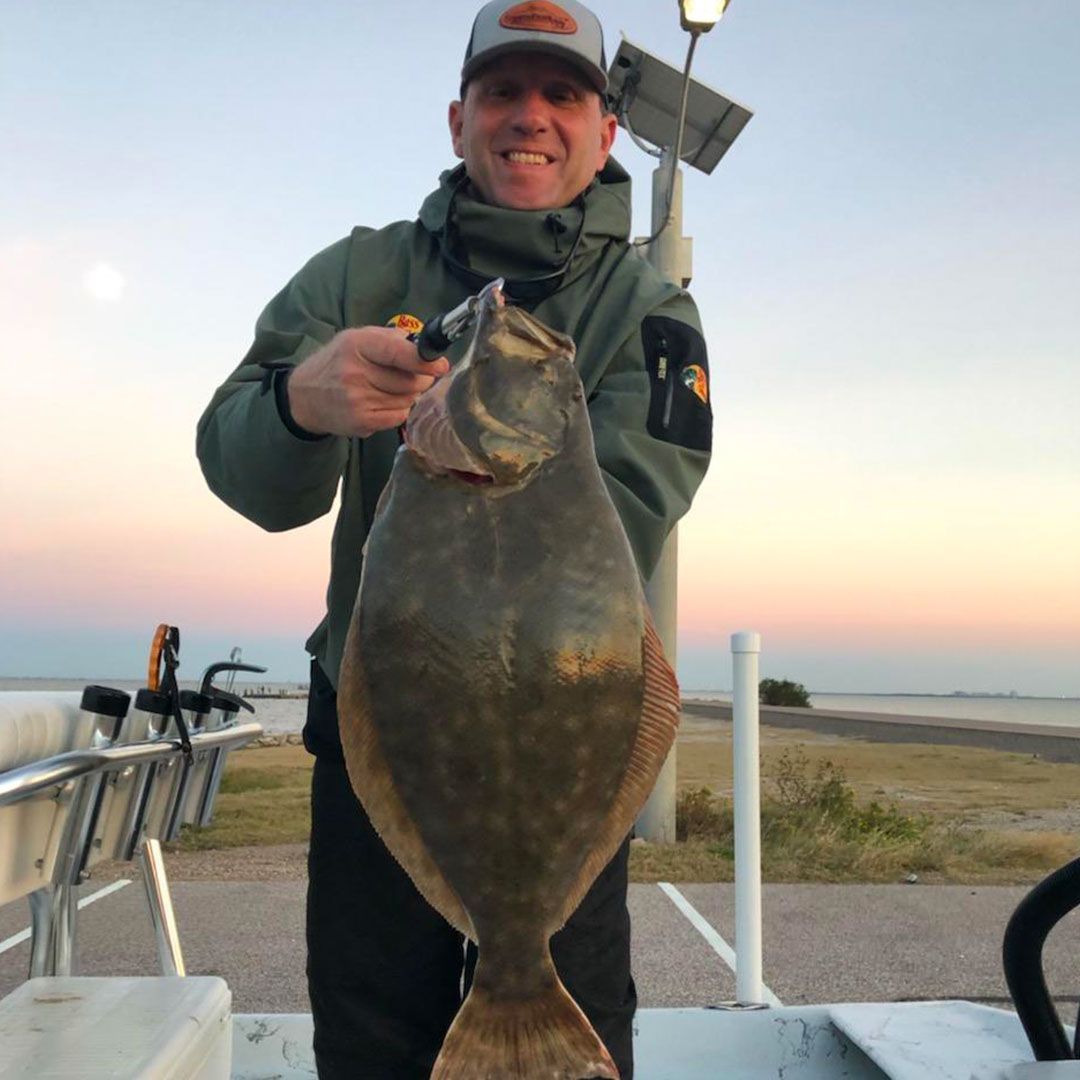 A man is holding a large fish in his hands