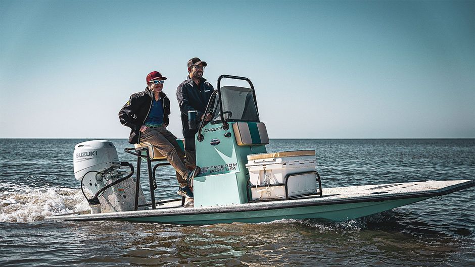 Two men are sitting on a boat in the ocean.