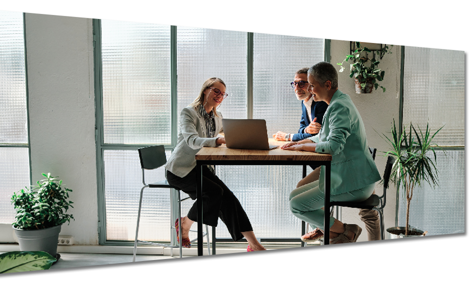 A group of people are sitting at a table with a laptop.