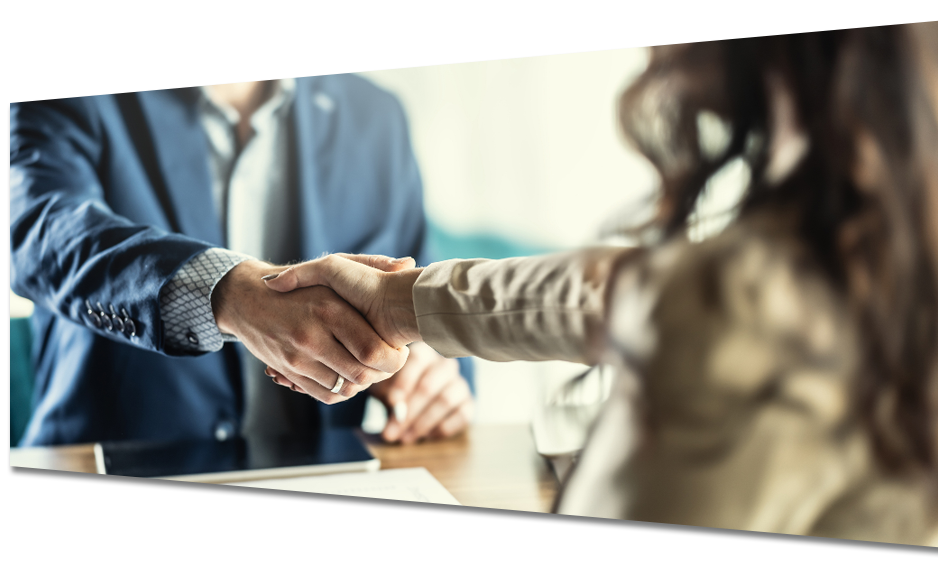 A man and a woman are shaking hands at a table.