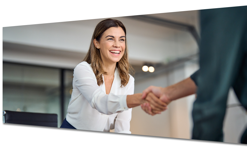 A woman is shaking hands with a man in an office.