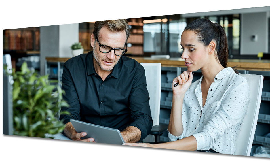 A man and a woman are looking at a tablet together.