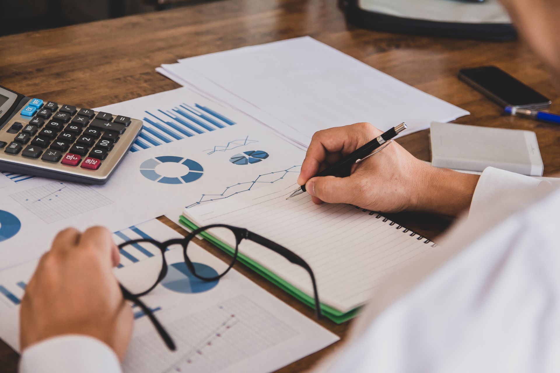 A man in a white shirt holding a pen working on calculating tax led to liquidation. A man in a white shirt holding a pen working on calculating tax led to liquidation.