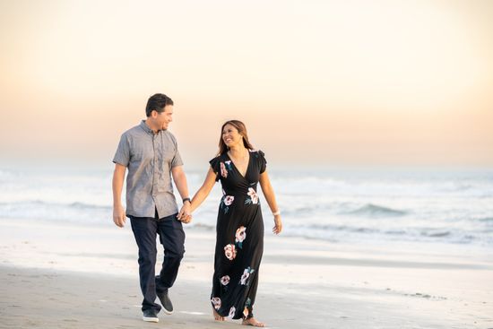 Image of married couple walking on the beach at sunset looking lovingly at each other
