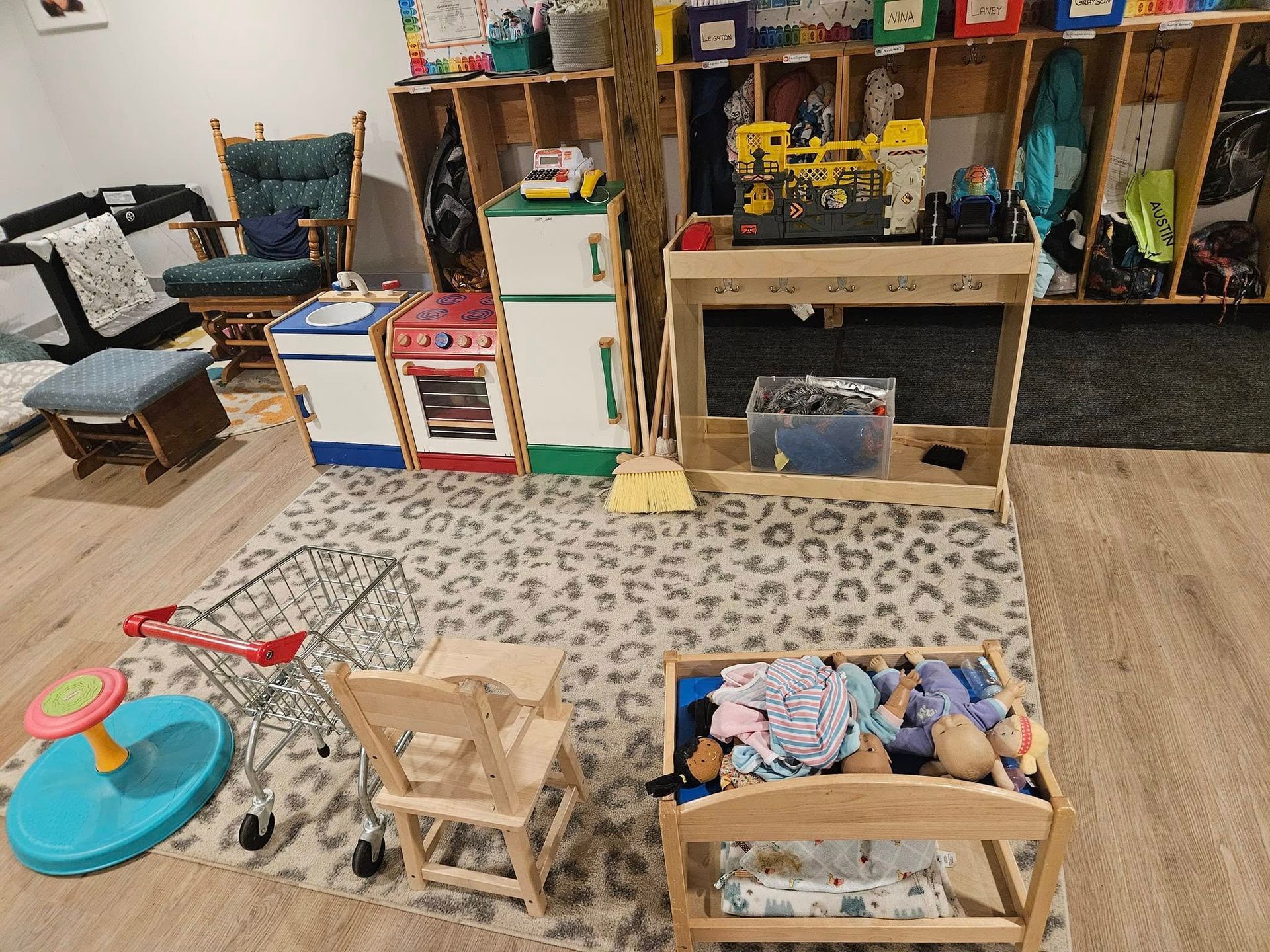 A play room filled with lots of toys and a leopard print rug.