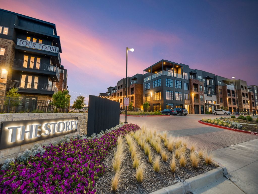 A large apartment building with a sign that says the store in front of it.