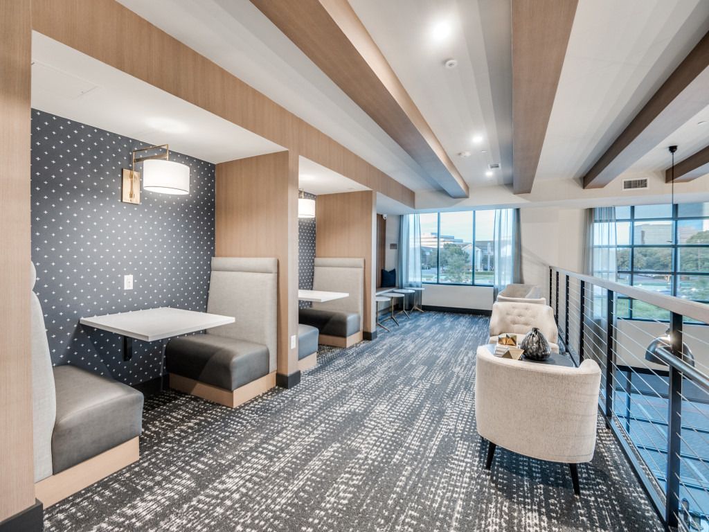 A long hallway with booths and tables in a hotel.