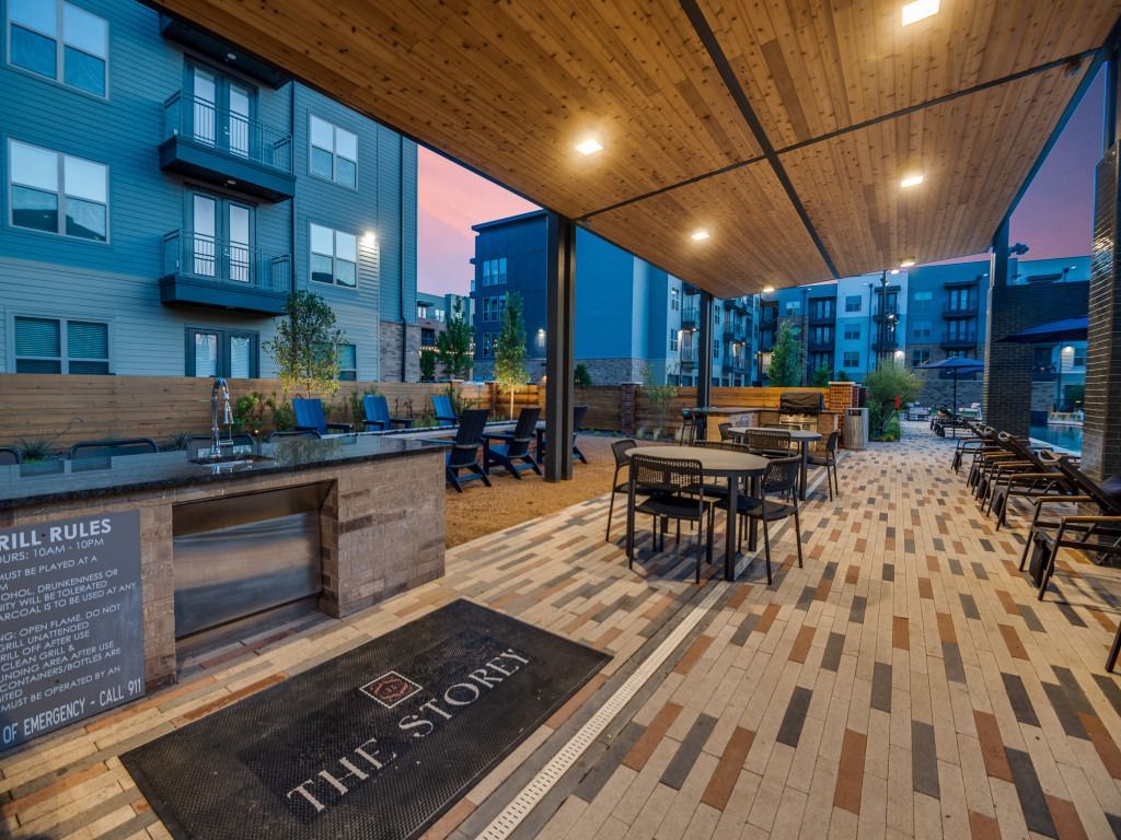 A patio area with tables and chairs under a canopy.