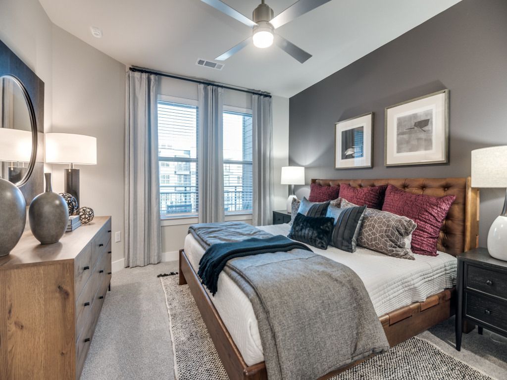 A bedroom with a large bed and a ceiling fan.