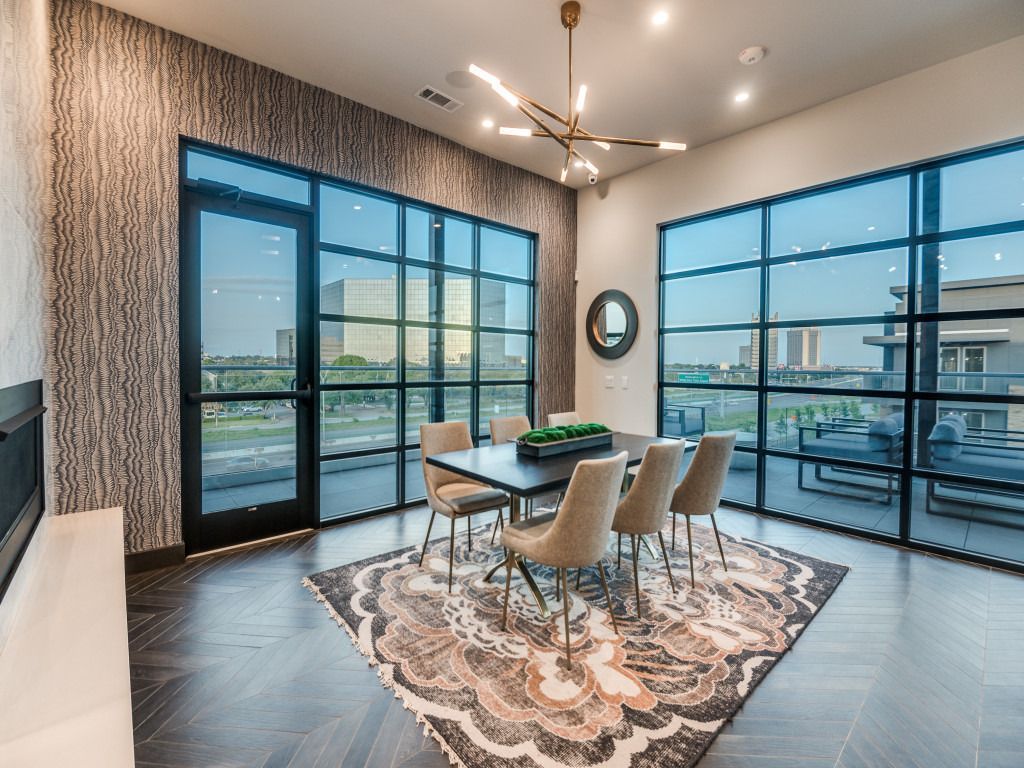 A dining room with a table and chairs and a rug.