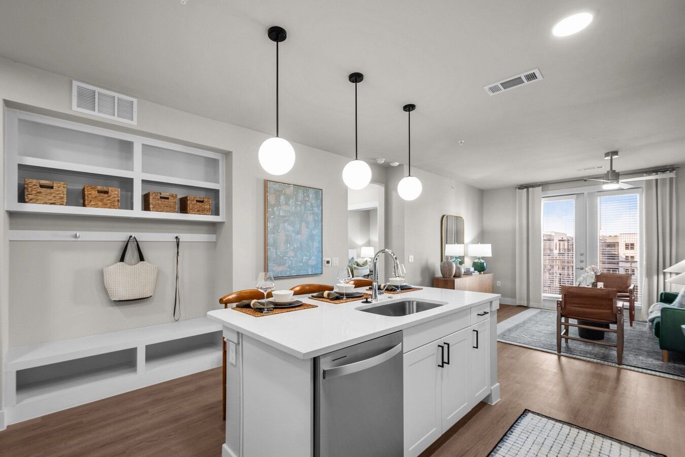 A kitchen with a large island , sink , dishwasher and stainless steel appliances.