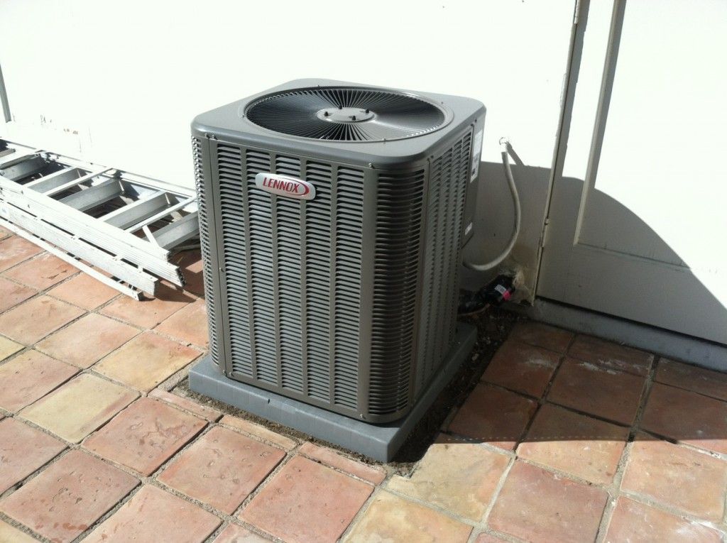 Air conditioner unit on brick patio.