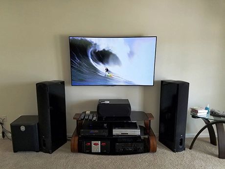 Living room entertainment center with flat-screen TV, speakers, and audio equipment beneath it