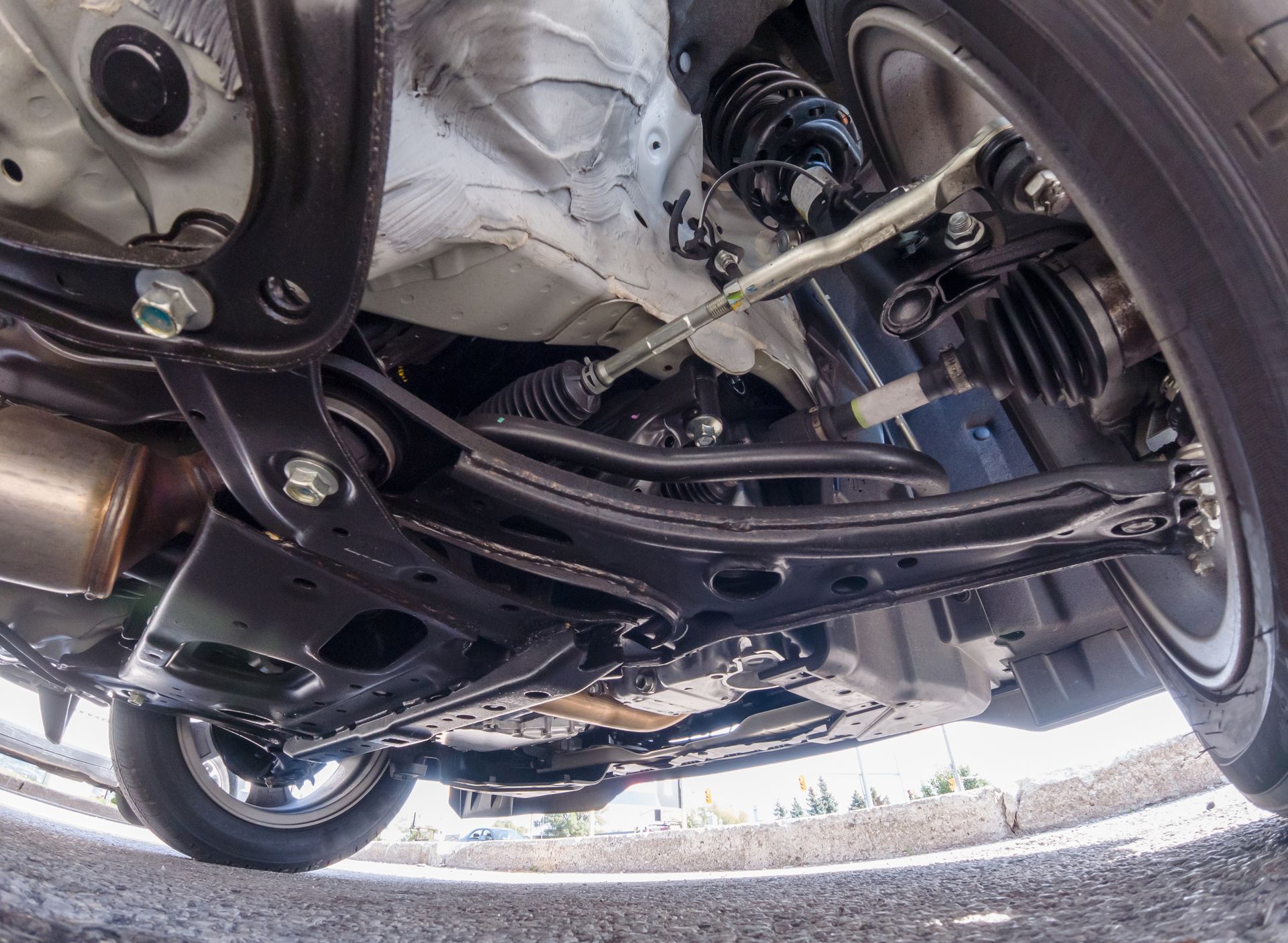 A low-angle view showing the black suspension components, axle, and undercarriage of a car.