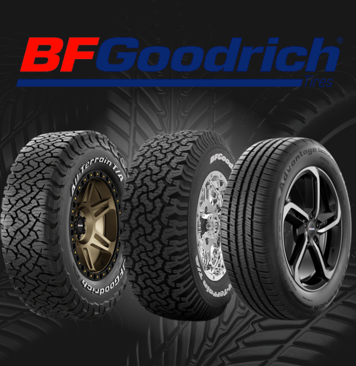 A close-up, high-angle shot of a black, rugged off-road tire with deep, aggressive treads and sharp patterns.