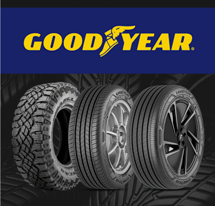 Close-up of a black tire with a deep, textured winter tread pattern against a dark background.
