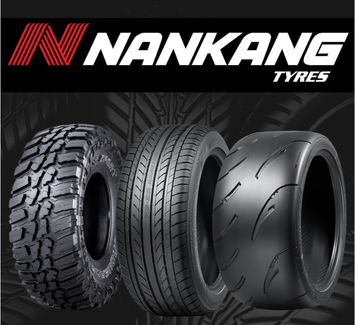 Four black rubber car tires standing side by side against a black background, each featuring a blue stripe on the tread.