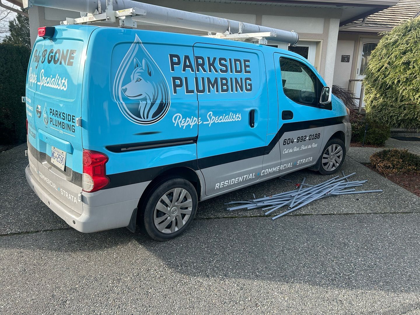 A blue parkside plumbing van is parked in front of a house.