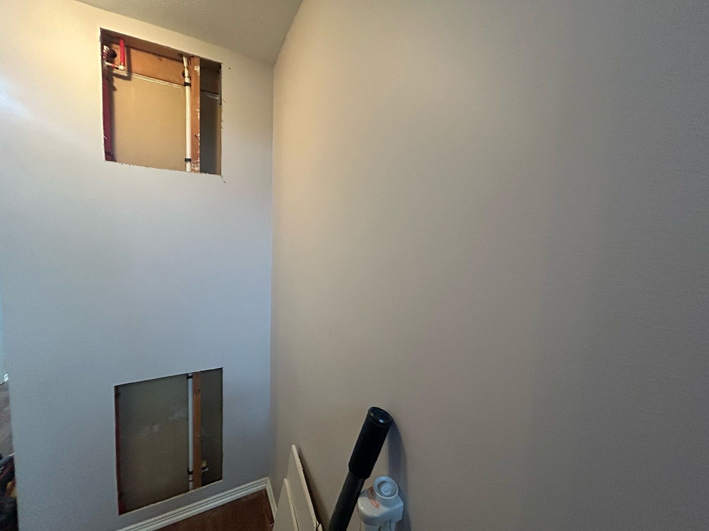 A room with a hole in the wall and a window.