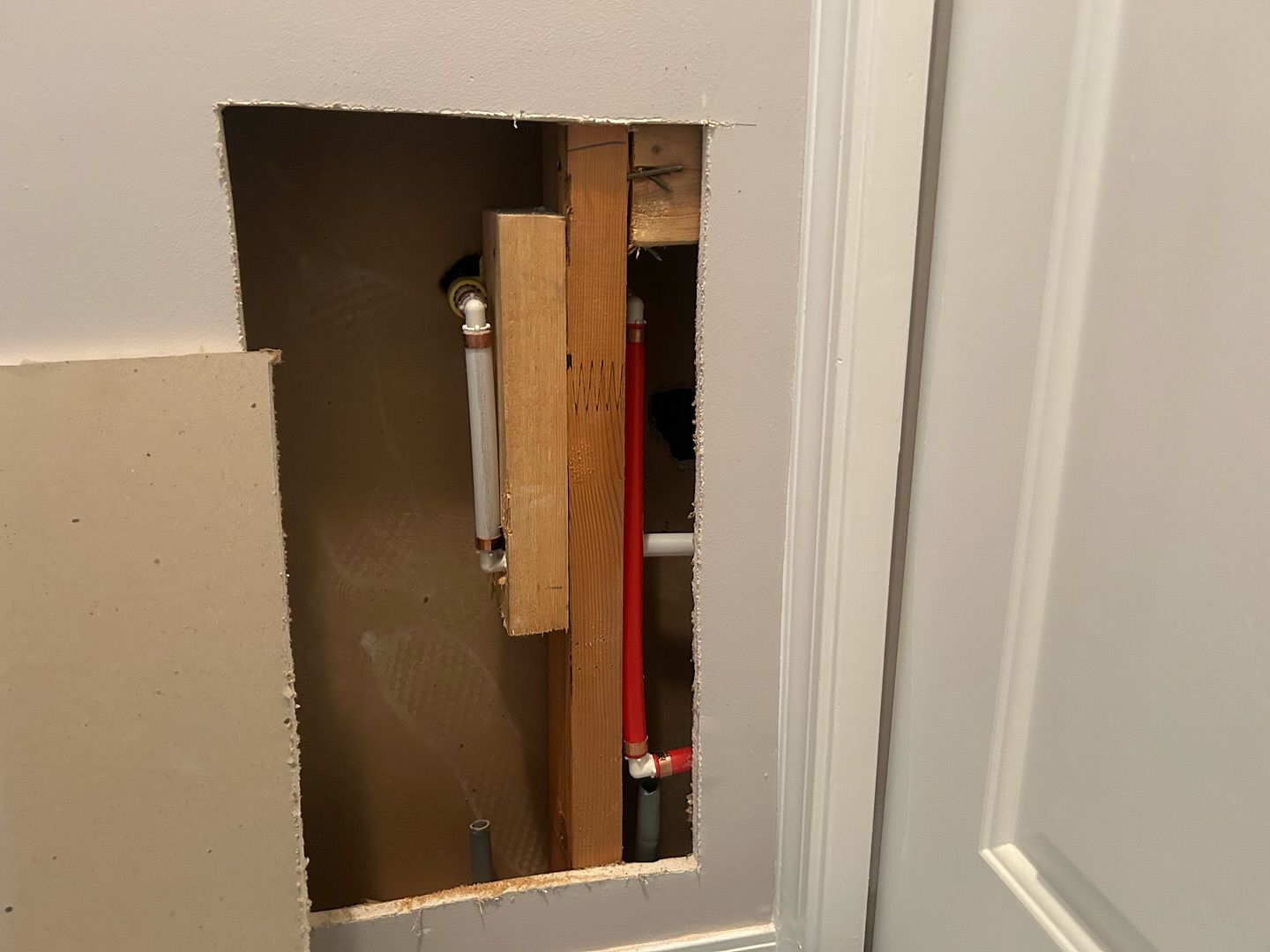 A hole in a wall with a pipe coming out of it