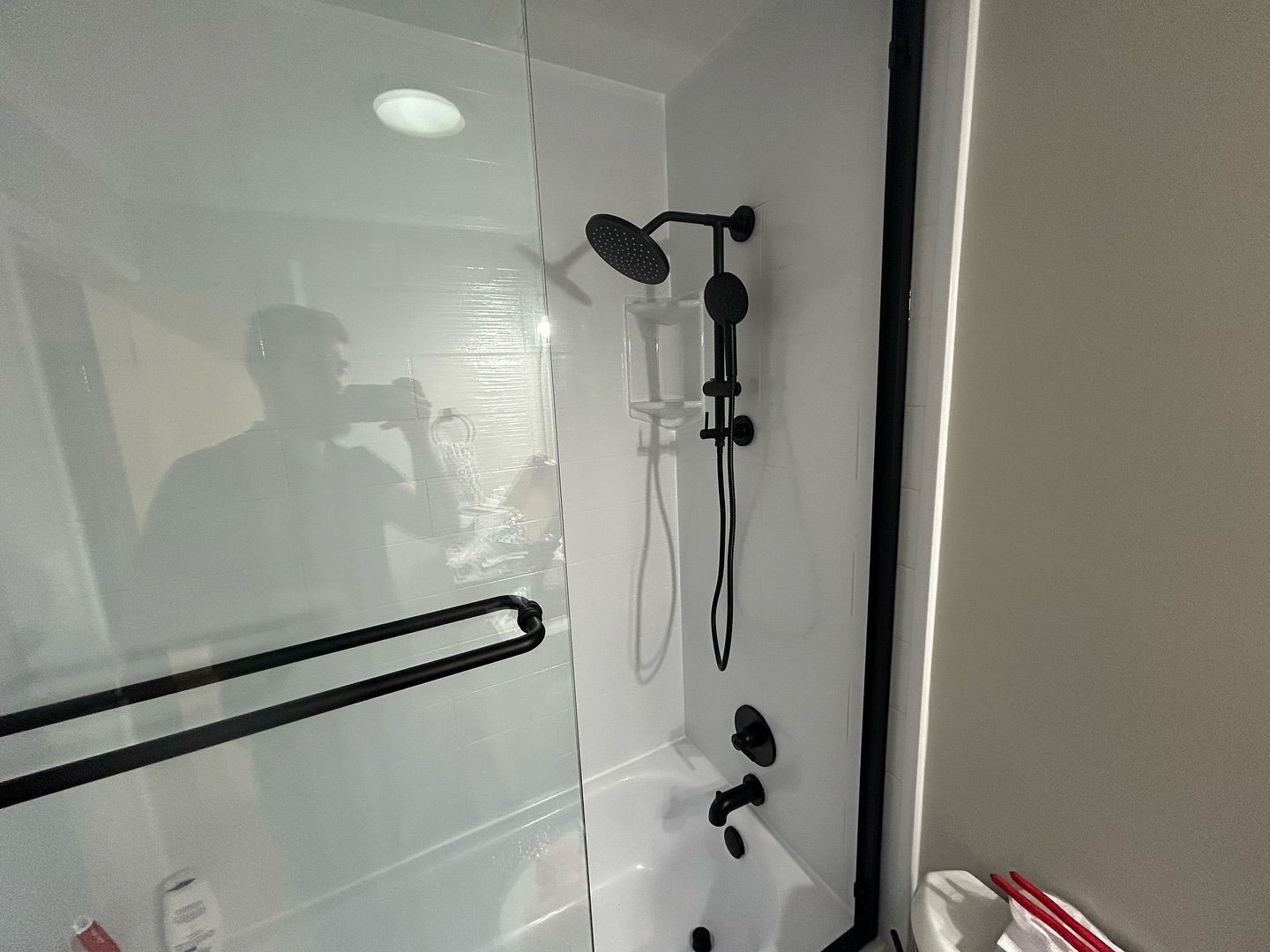 A bathroom with a tub , shower , and mirror.