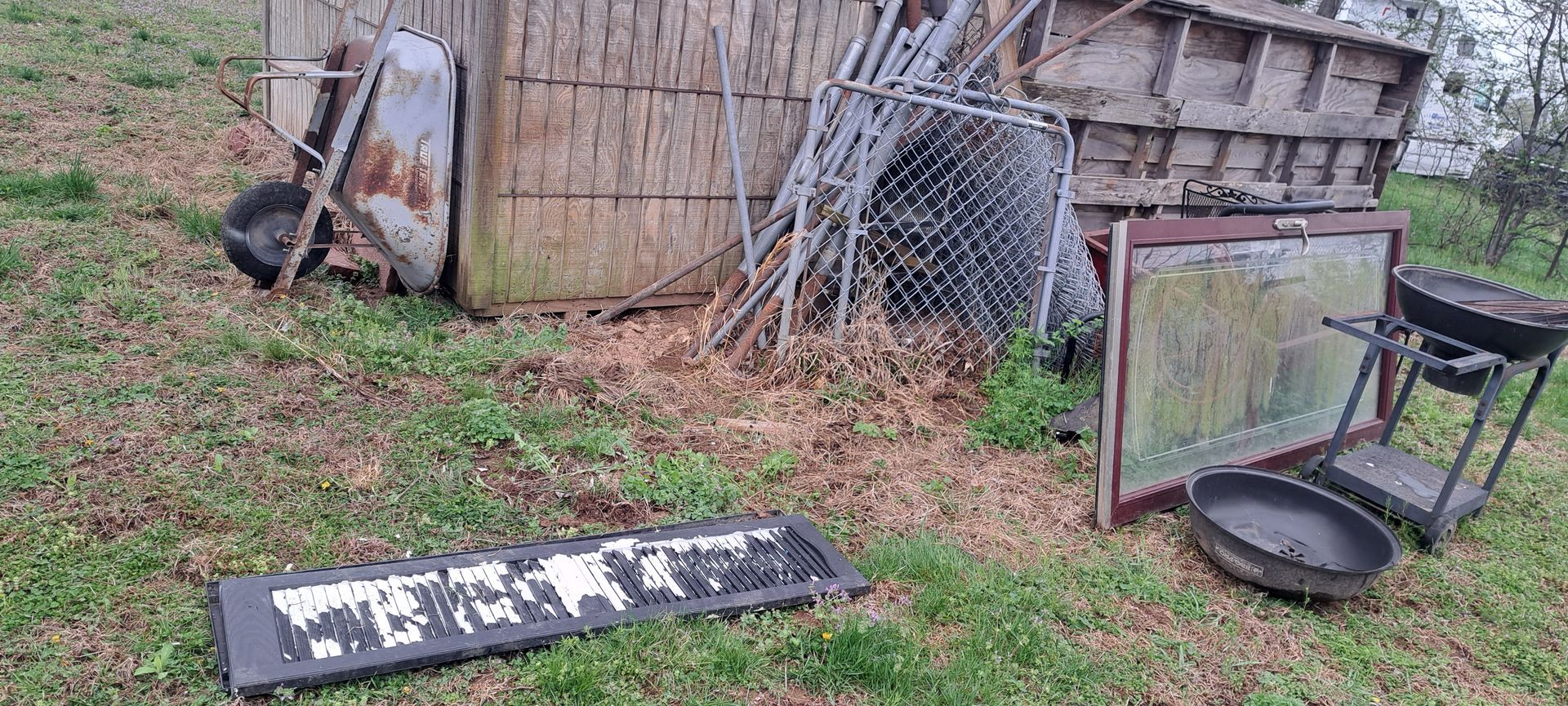 A bunch of junk is laying on the ground in a field.