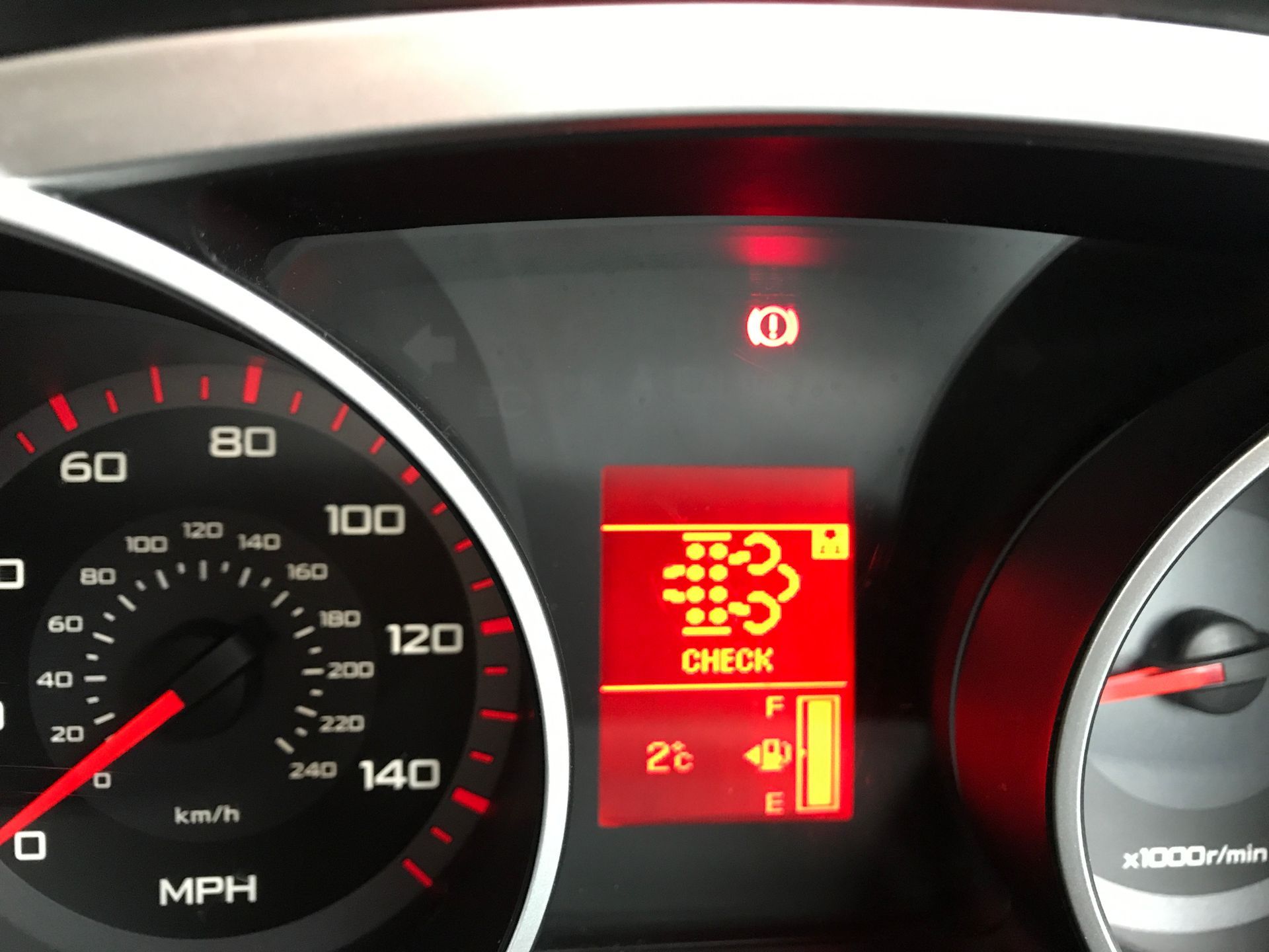 A close up of a car dashboard with a check button