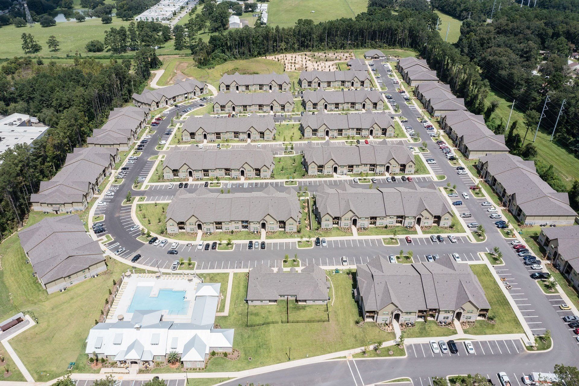 Aerial view of a multi-building apartment community with a central pool.