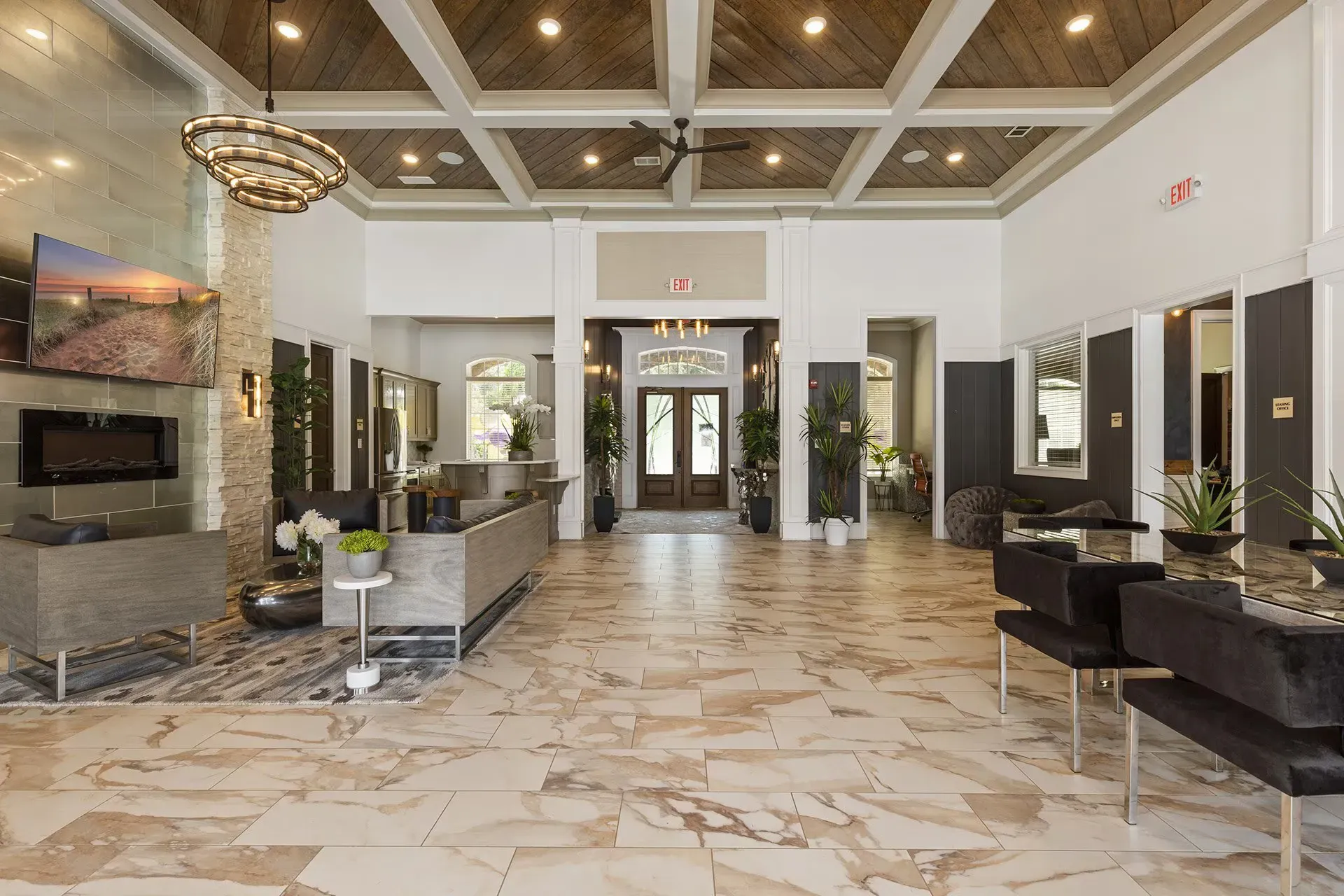 Interior lobby of an apartment building with seating, plants, and double doors.