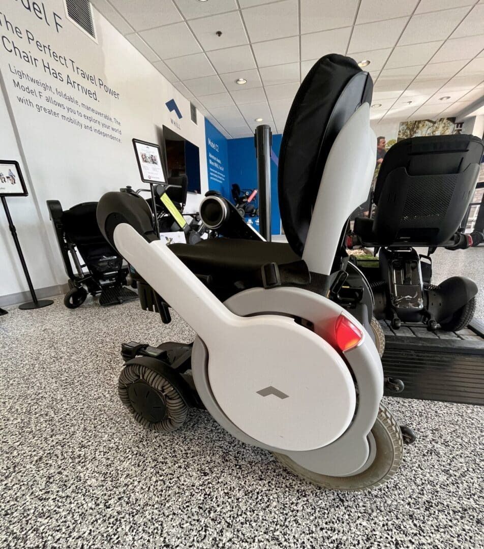 Power wheelchair with a white, curved armrest in a store.