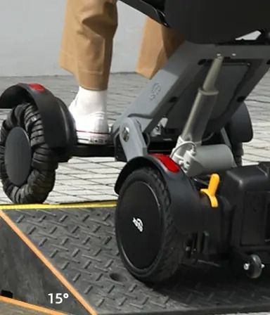 A person on a mobility scooter ascending a 15-degree ramp, demonstrating accessibility.