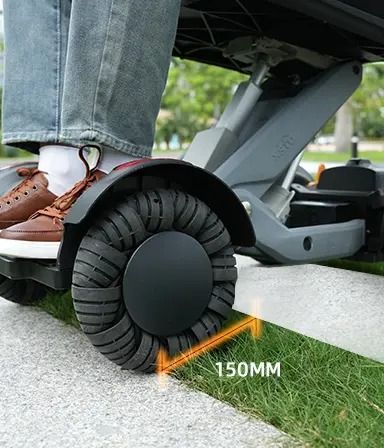 Person riding a gray mobility device; the wheel has a 150mm clearance over a grassy area.