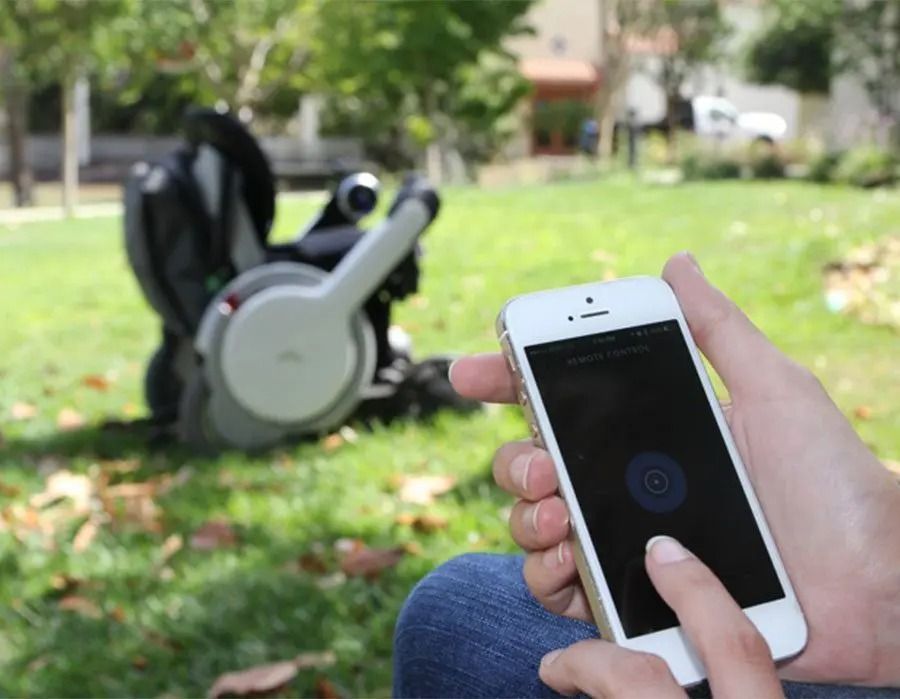 Person operating a smartphone with a finger, a power chair in the park.