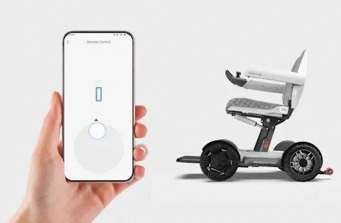 A person holding a phone, controlling a gray and white remote-controlled mobility device.