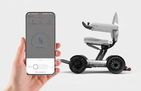 Hand holding phone with an app controls a small, silver and black personal mobility device.