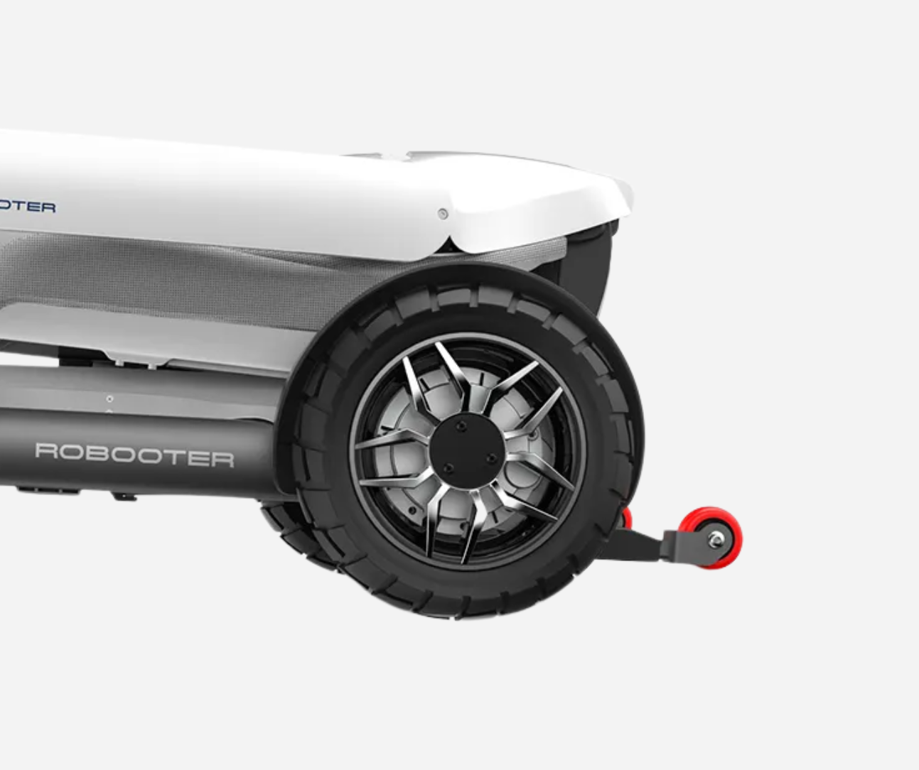 Close-up of a white and black wheeled robot, with a dark tire, and small red wheel.