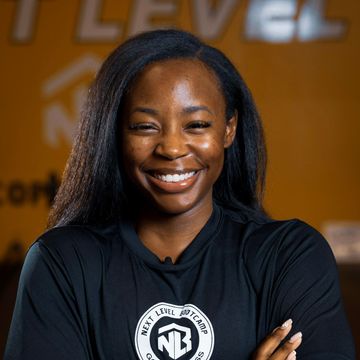 A woman wearing a black shirt with nb on it. Coach Adri